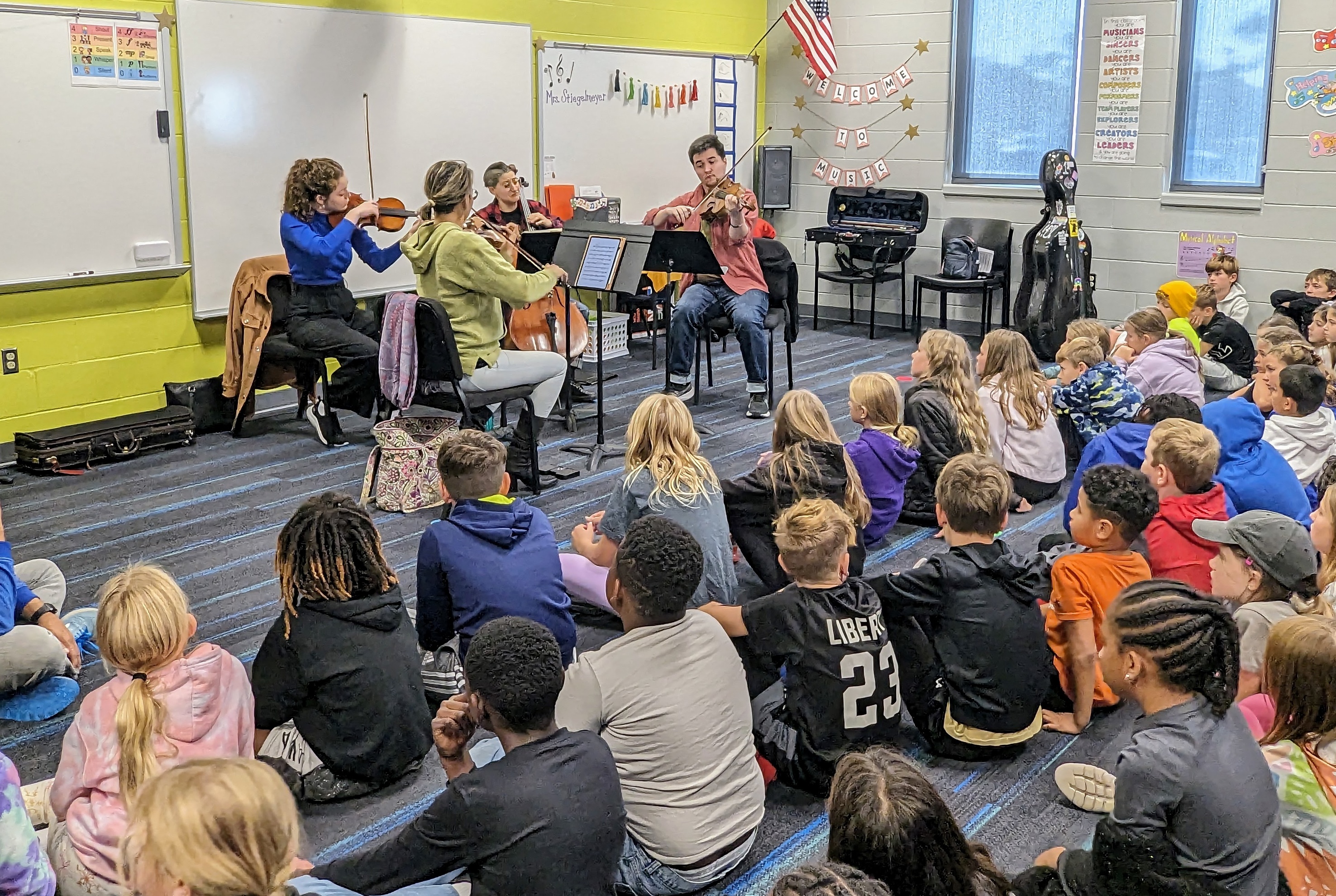 A string quartet performs in a classroom for K-12 students