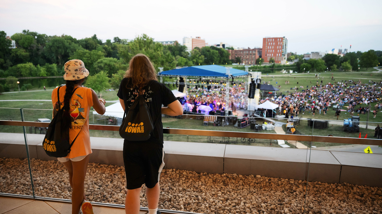 Two University of Iowa students watch the Fall Welcome Concert from the balcony outside Hancher Auditorium